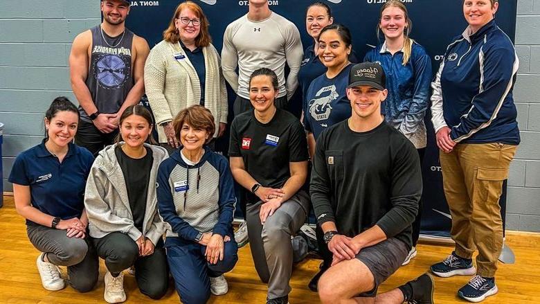 Group photo of faculty and students in front of Penn State 蒙特中音 athletics banner after the Functional Movement Screen.