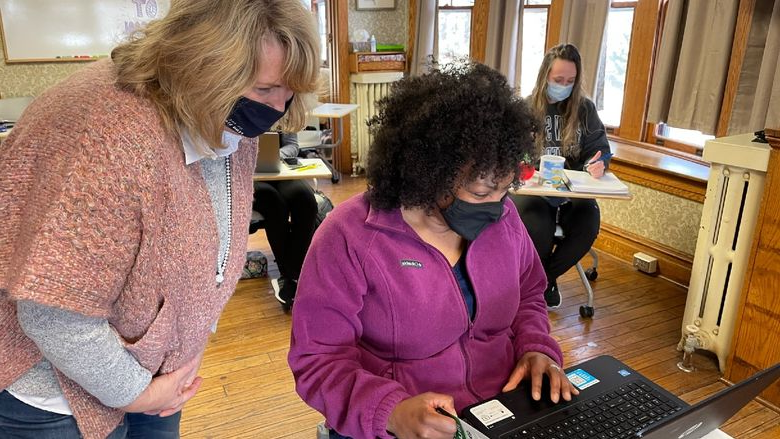 female student at computer with faculty helping 